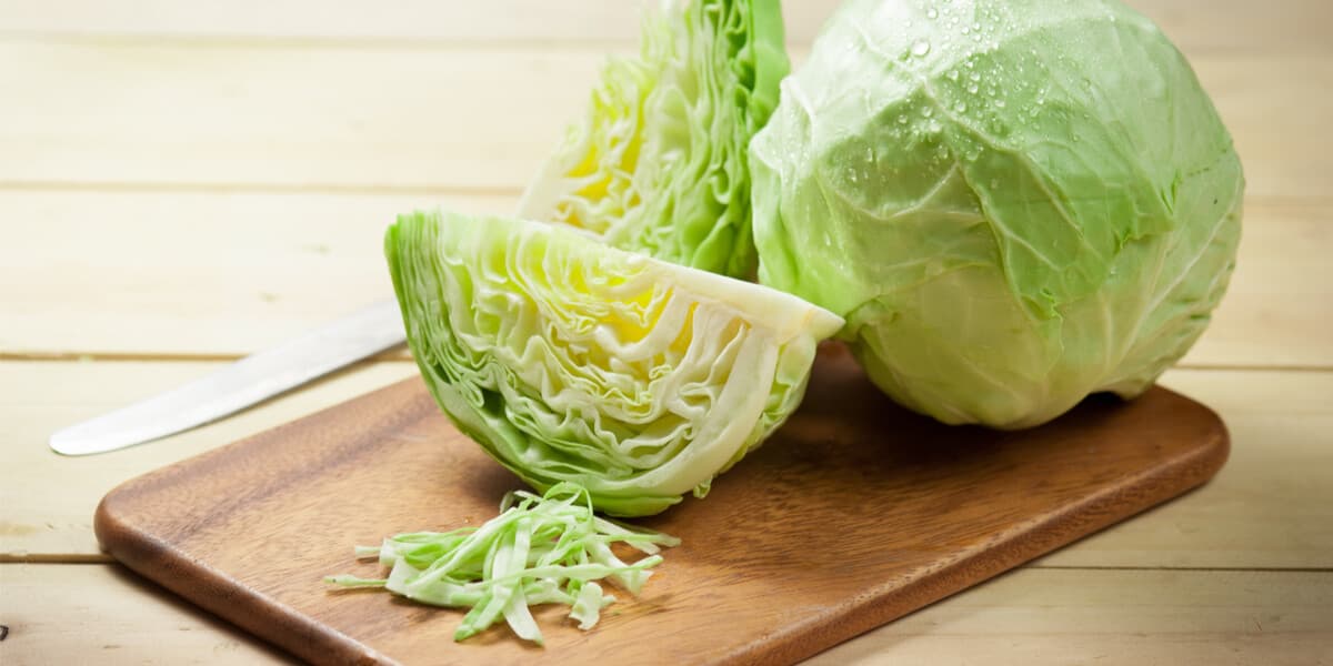 cabbage wedges and a whole cabbage on a wooden cutting board